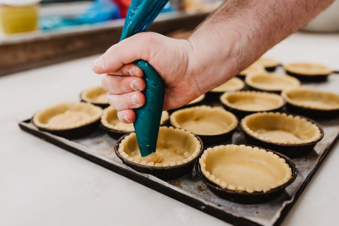Crop baker squeezing dough on tray