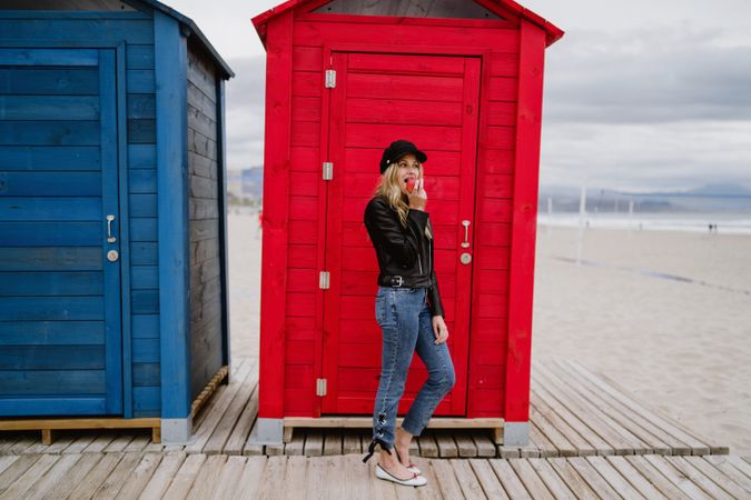 Woman eating an apple near bright wooden cabins