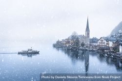 View of Hallstatt town and with a  boat in the lake under snowfall bEdmG4