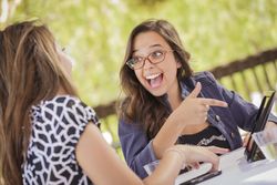 Smiling Women Working Together on Tablet Computer
