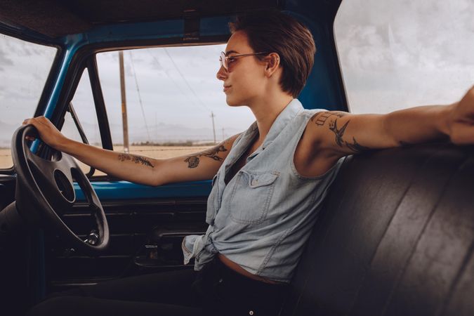 Side view of attractive woman driving an old truck
