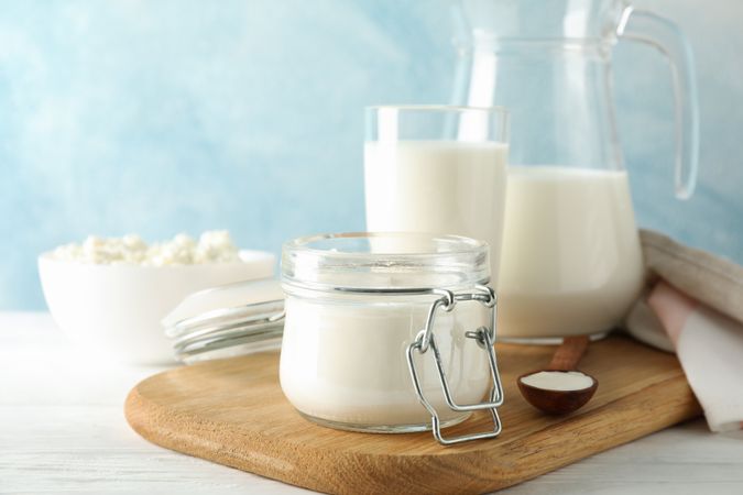Fresh dairy products on plain wooden table, copy space