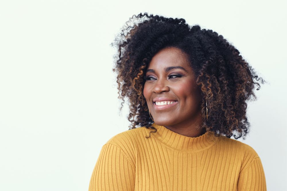 Studio shot of a happy Black woman in yellow shirt