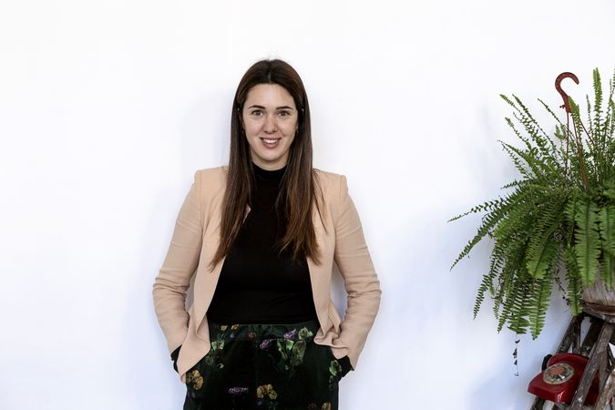Portrait of a happy female leaning on wall looking at camera