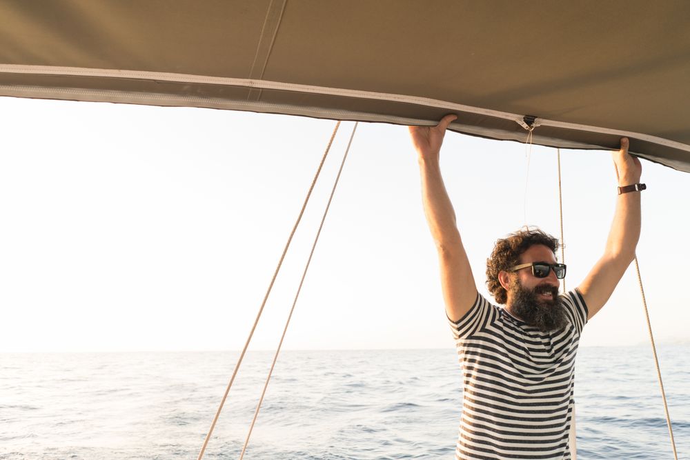 Smiling man on yacht on water