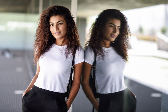 Arab woman leaning against window of office building