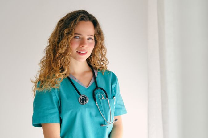 Smiling female doctor in uniform in white room