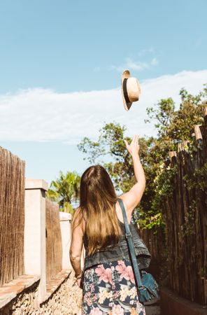 Happy woman throwing hat up
