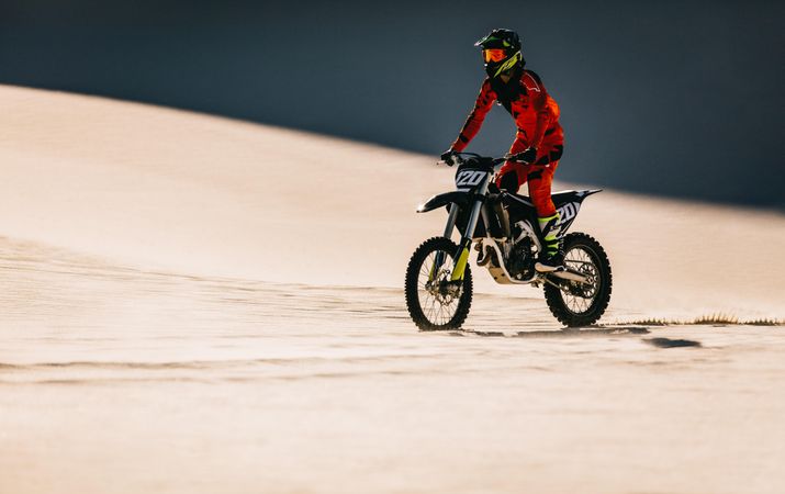 Moto racer riding bike in desert
