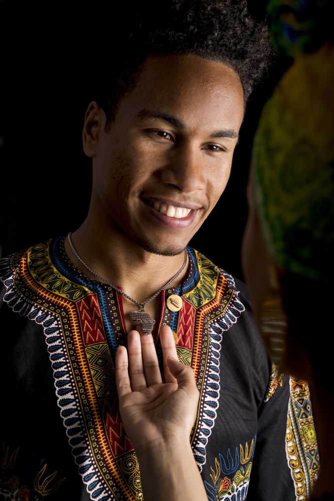 Black man smiling looking to hugging woman