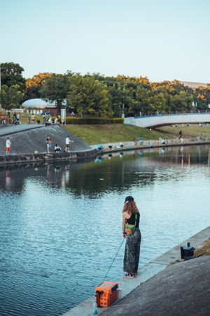 Woman standing on still river bank