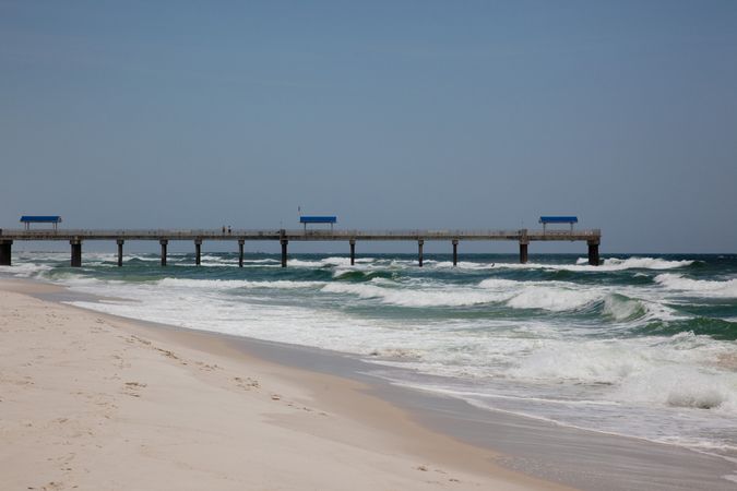 Sand beach with pier along Gulf Coast Of Alabama