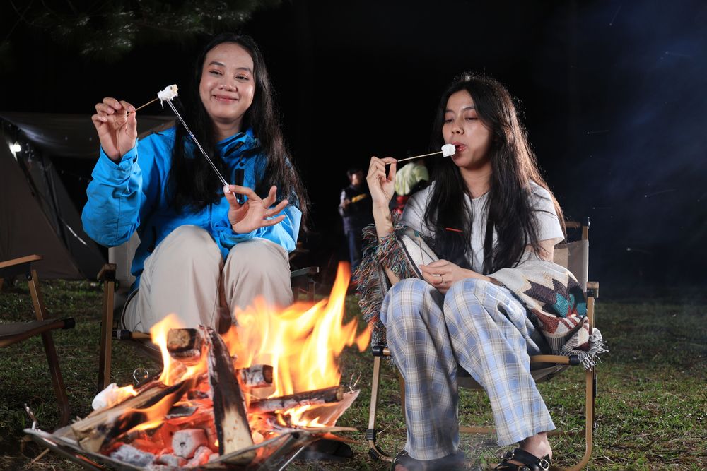 Two Asian Friends Camping and Making Smores at Campfire