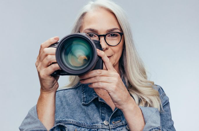 Older woman photographer taking pictures with dslr camera