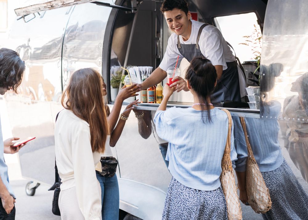 Happy food vendor selling drinks to customers