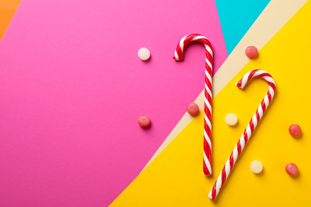 Composition with sweet candies on multicolored background, space for text