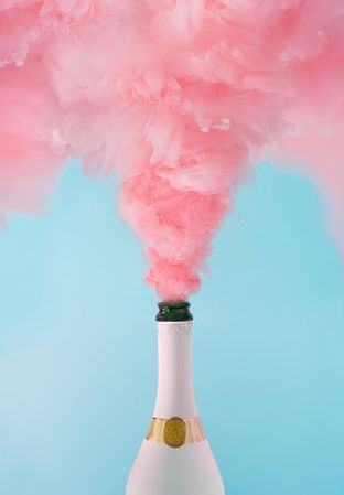 Pastel pink champagne explosion on blue background
