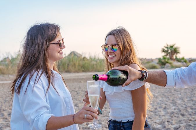 Happy family drinking wine on beach