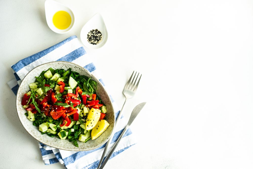 Top view of big grey bowl of delicious tomato salad with copy space