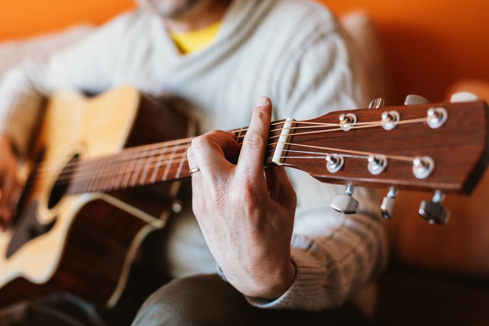 Detail of a man playing the guitar