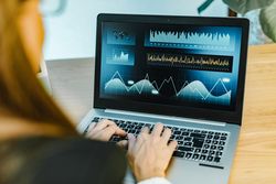 Female trader typing on laptop