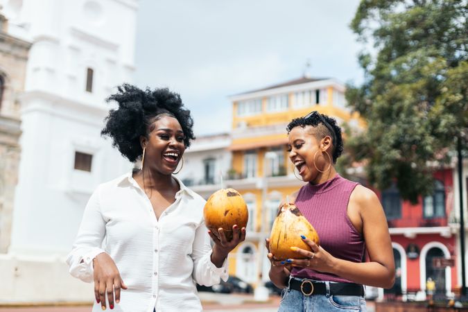 Latin American women having fun in the city drinking coconuts