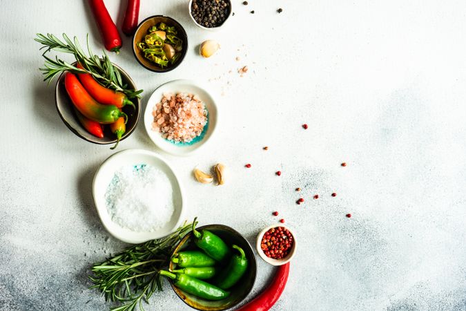 Top view of marble counter with peppers, herbs and salt with space for text