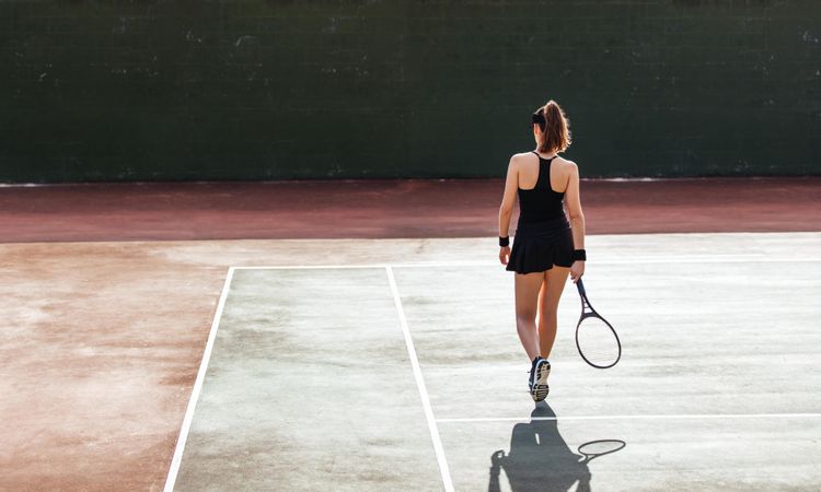 Full length rear view of female tennis player on the court
