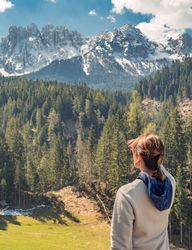 Woman covering face from sun and looking at amazing landscape