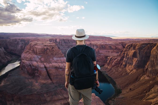 Bearded traveler holding camera on canyon