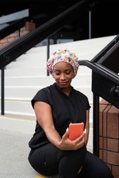 Woman nurse in head covering and scrubs takes a selfie on work break