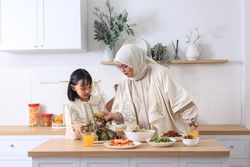 Mom and Daughter Preparing Ketupat Lebaran for Eid Al Fitr Celebration at Home.