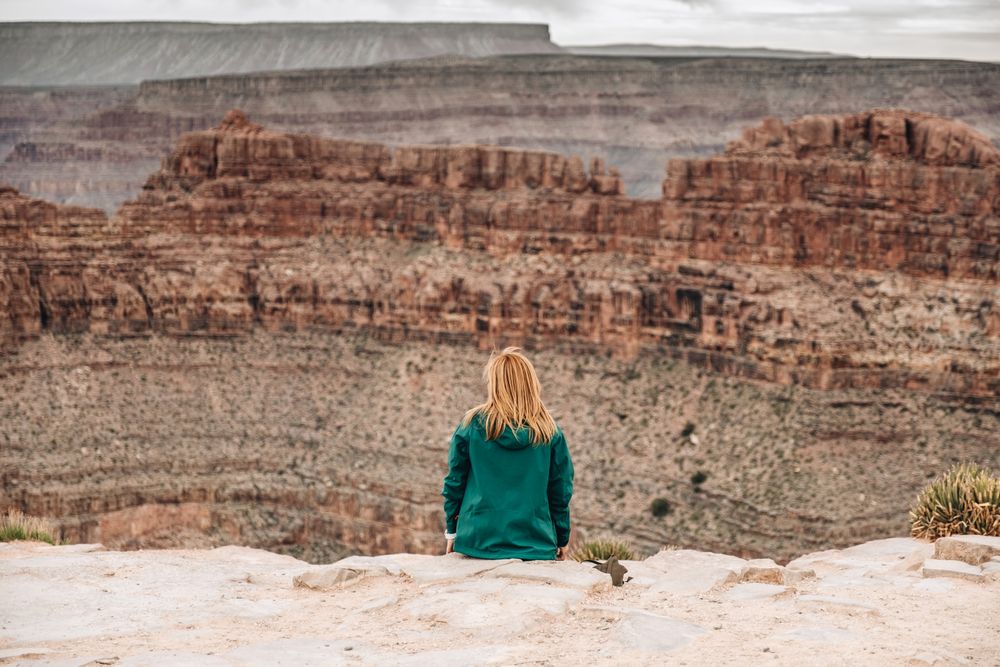 Female relaxing on cliff and admiring picturesque view