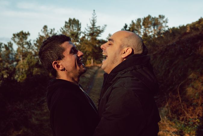 laughing men hugging in countryside road