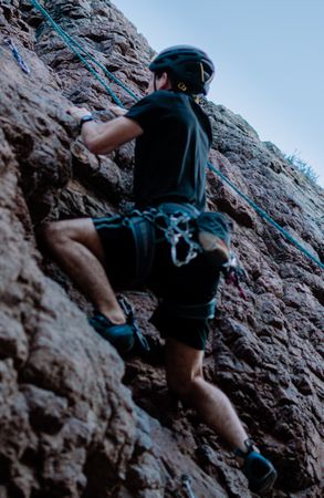 Man in dark t-shirt climbing mountain