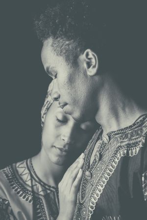 Woman with eyes closed clinging to ethnic man