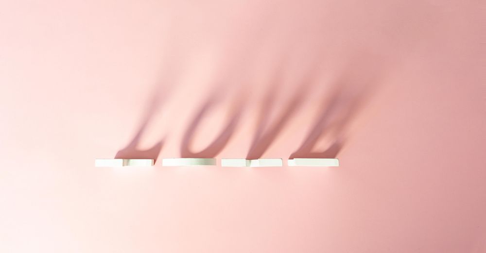 “Love” written in shadow on pink background