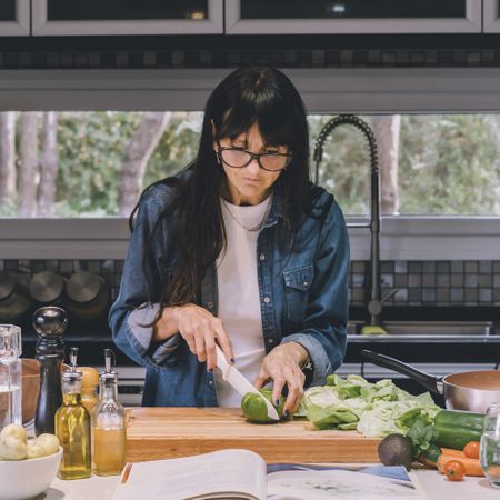 Woman reading recipe while preparing food.