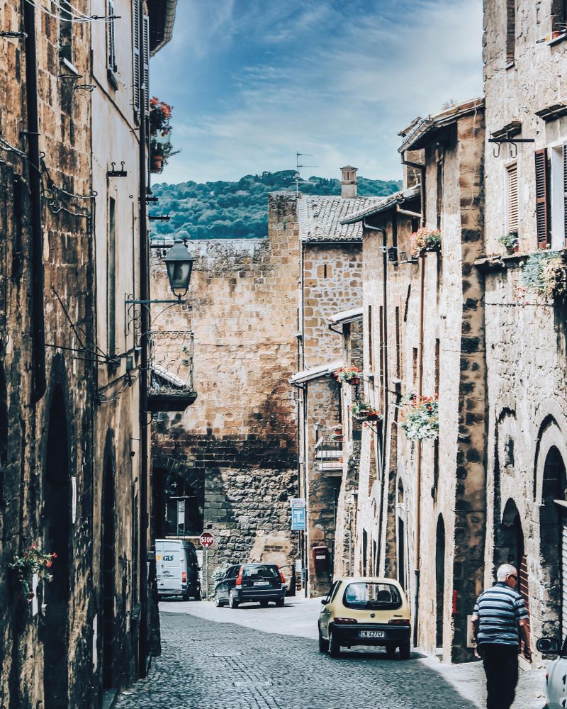 Cars parked in narrow street between buildings