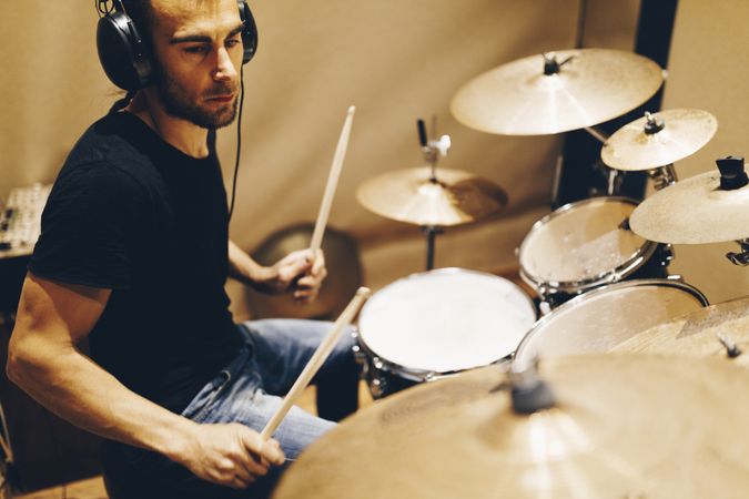 Man with headphones playing on drums