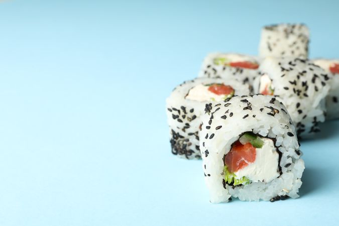Delicious sushi rolls on blue background. Japanese food