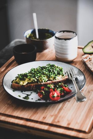 Avocado toast on sourdough bread, with cherry tomatoes  coffee, with bowl