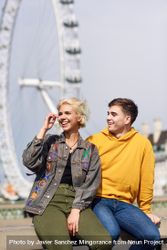 Male and female friend sitting in front of London Eye 4jed95