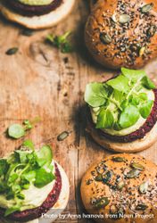 Close up, vegan burgers on seeded buns arranged on wooden board, vertical composition, copy space 43xprb