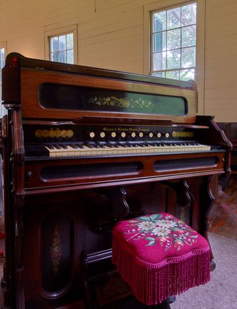 Antique church organ with embroidered seat
