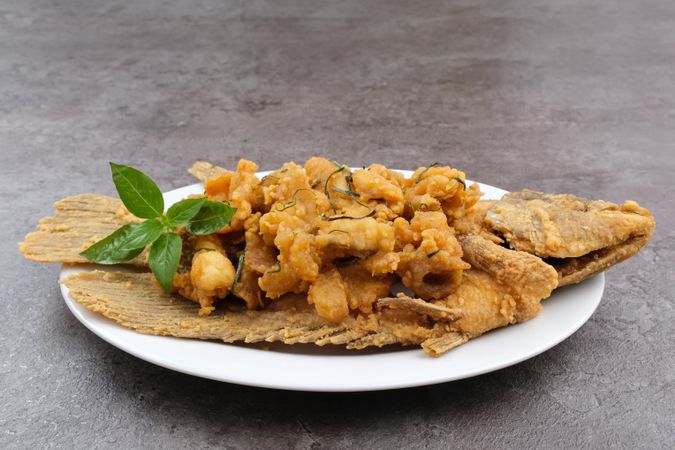 Gurame Saos Telur Asin. Crispy fried gourami fish covered with salted egg sauce. Indonesian food
