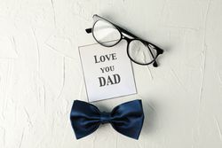 Inscription love you DAD, blue bow tie and glasses on blank background, space for text and top view