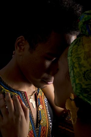 Black man holding necklace and looking away