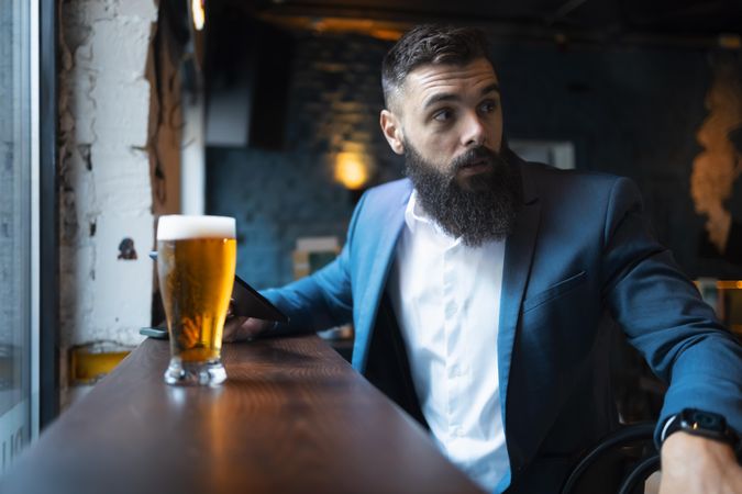 Man in suit with pint of beer