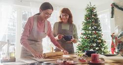 Portrait of Adult Woman Preparing Gingerbread for Christmas While her Mature Mother is Helping.